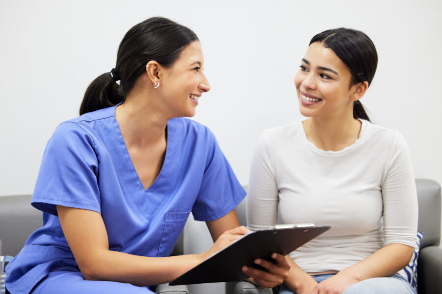 nurse and woman talking in medical clinic